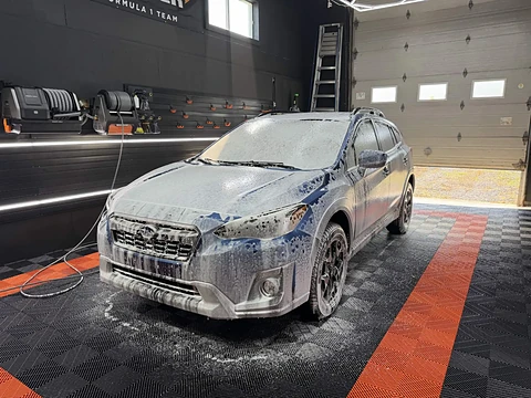 Véhicule recouvert de mousse de lavage dans l'atelier Prestige Esthétique Auto