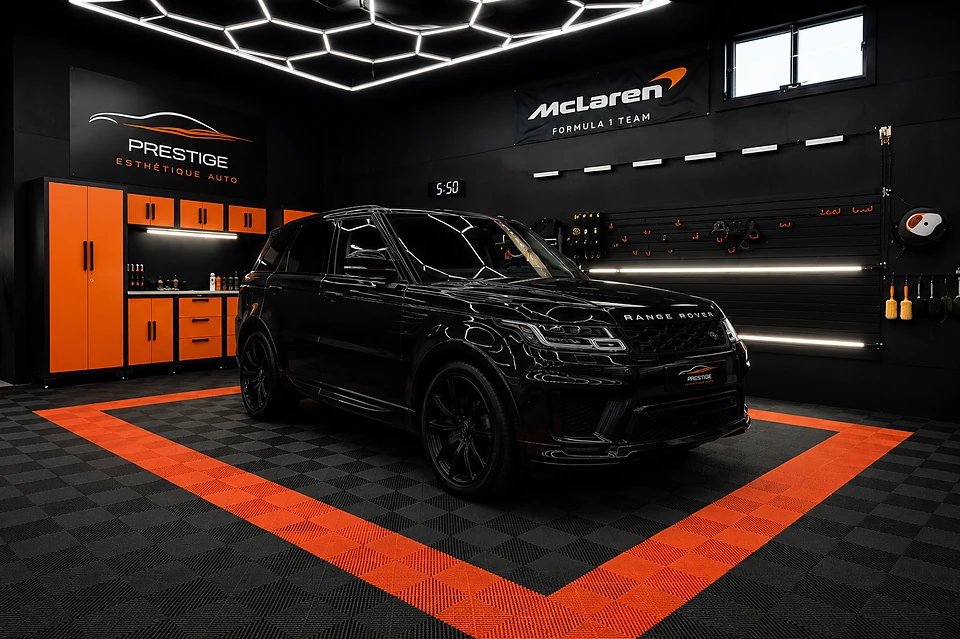 Range Rover Sport noir dans l'atelier Prestige Esthétique Auto sous l'éclairage LED hexagonal